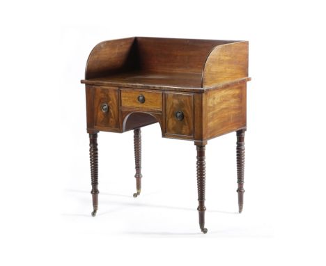 A GEORGE IV MAHOGANY WASHSTAND C.1820 with a three quarter gallery, above a later frieze drawer flanked by false fronts, on r