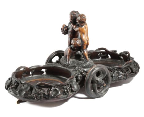 A BLACK FOREST CARVED WOOD WINE DECANTER WAGON C.1880 the centre with three frolicking Bacchanalian cherubs, with twin bottle