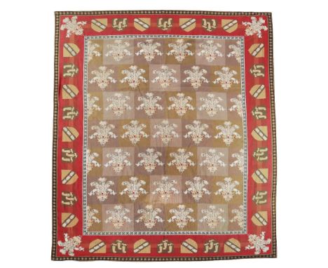 A NEEDLEPOINT TAPESTRY CARPET C.1870-80 the chequerboard centre with Prince of Wales plumes of feathers, within a heraldic sh