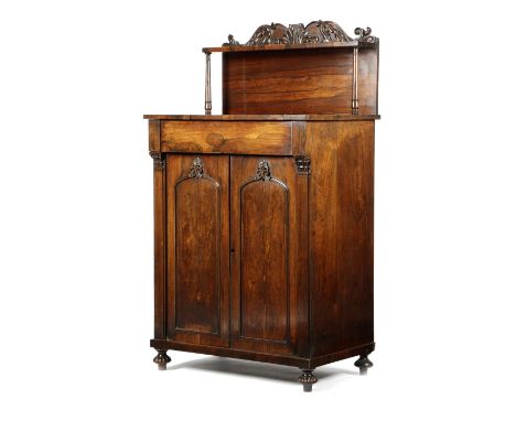 λ A WILLIAM IV ROSEWOOD SIDE CABINET C.1825 the raised back carved with scrolling leaves, fitted with a frieze drawer, above 