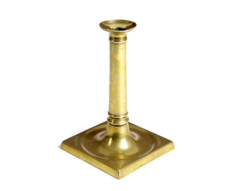 A LATE GEORGE III BRASS SOCKET CANDLESTICK C.1800 the column stem topped by a broad sconce and raised on a heavy gauge square