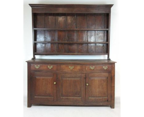 An 18th century oak dresser, the three shelf plate rack over three drawers and three fielded panel cupboard doors, h. 204 cm,