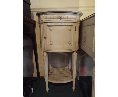 A Single Oval Cream Painted Bedside Cabinet with Drawer Over Pot Cupboard and Caned Stretcher Shelf.