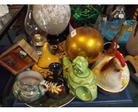 A Tray of Ceramics Glassware to Include Novelty Teapot, Oil Lamp, Egg Crock, Pickled Onion Dish, Decorated Plate Etc. 