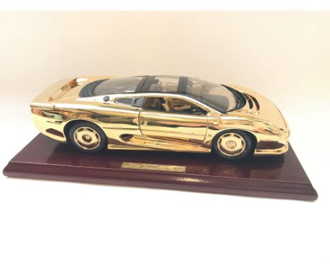 A 22ct Gold Plated Jaguar XJ220 with display box 1:18th scale.