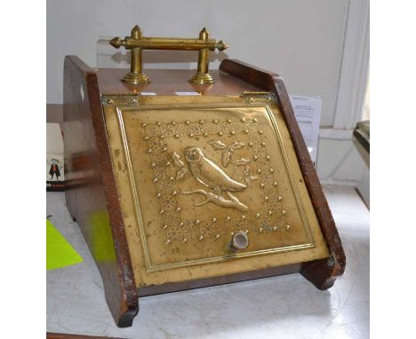 An oak and brass coal box, the hinged cover with an embossed brass panel depicting an owl, fitted brass carrying handle and s