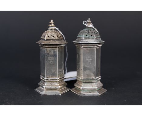 A pair of Carrington &amp; Co silver pepperettes of hexagonal form (one has corrosion to lid), hallmarked London 1927, total 