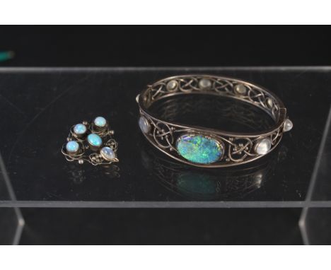 A white metal pierced design bangle set with large centre opal stone and cabochon moonstones plus an opal and moonstone brooc