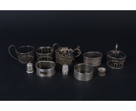 Three silver napkin rings, four silver cup holders (no glass) plus two silver thimbles, approx 134g