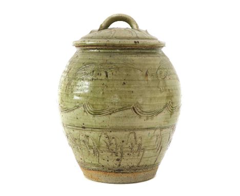 *Jim Malone (b.1946),a stoneware jar and cover, with a flecked trailing green glaze, incised with fish above waves and furthe