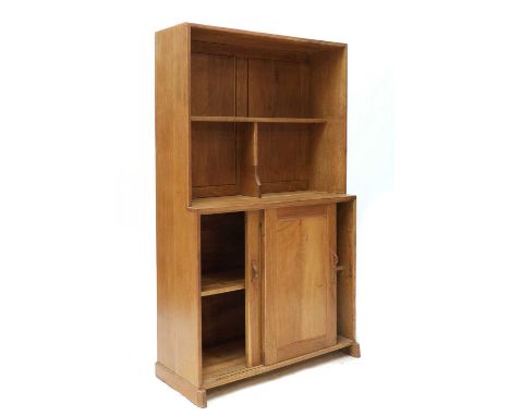 A Cotswold oak dresser,of plain form centred with a shelf and a division over two sliding cupboards, with a panelled back, ca