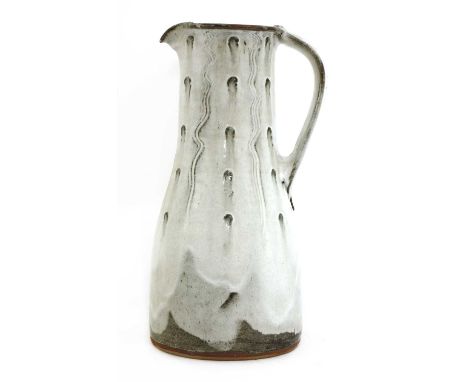 *Jim Malone (b.1946),a stoneware jug, of tapering form with thumb impressions and vertical combed details, in a trailing milk