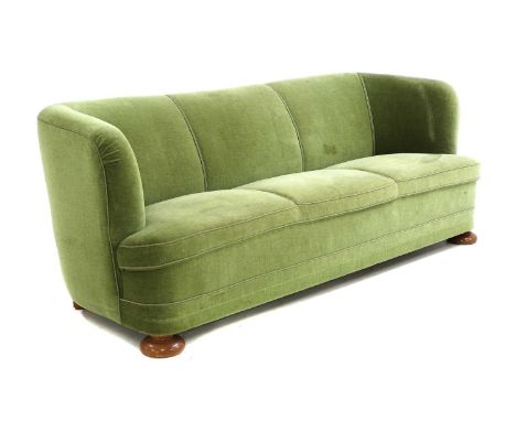 A Danish Art Deco three-seater sofa,1940s, with sprung seats, upholstered in green velour, on turned oak front feet,190cm wid