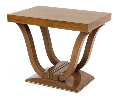 An Art Deco walnut low console table,the plain top raised on shaped supports, on a plinth mounted with brass rails,75.5cm wid