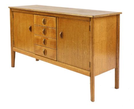 A Gordon Russell oak sideboard,with a chamfered edge, over four central drawers flanked by cupboards, enclosing a half shelf 