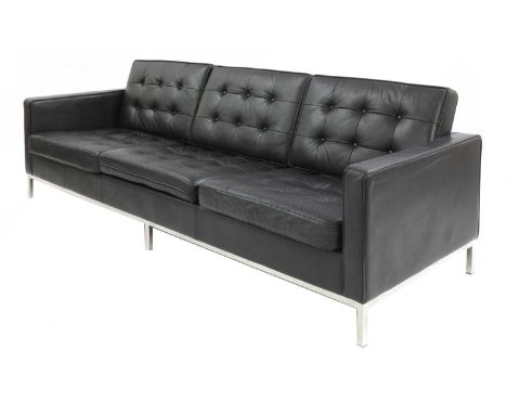 A modern 'Relax'-style black leather sofa,in the manner of Florence Knoll, with buttoned back and seat cushions, on a chromed