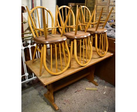 A rectangular refectory-type trestle table, 151 x 67, and a set of six Ercol-type elm seated comb back chairs.