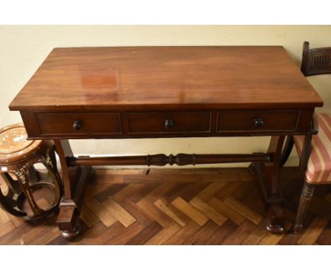 An early Victorian mahogany writing table, the rectangular top above three frieze drawers raised on shaped end supports unite