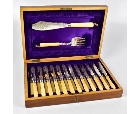 A walnut cased set of twelve silver plate bladed and ivorine handled fish knives and forks with servers set to the lid.Additi