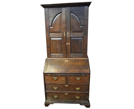 A George III oak bureau bookcase, the upper section with stepped cornice above twin fielded doors enclosing fitted interior o