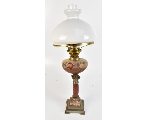 A reproduction oil lamp with frosted glass reservoir raised on marble Corinthian column supports, height including chimney 63