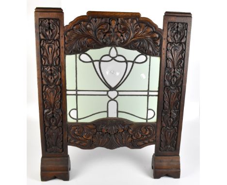 An Arts &amp; Crafts carved oak firescreen with inset leaded glass panel, 80 x 68cm (glass af).Additional InformationA large 