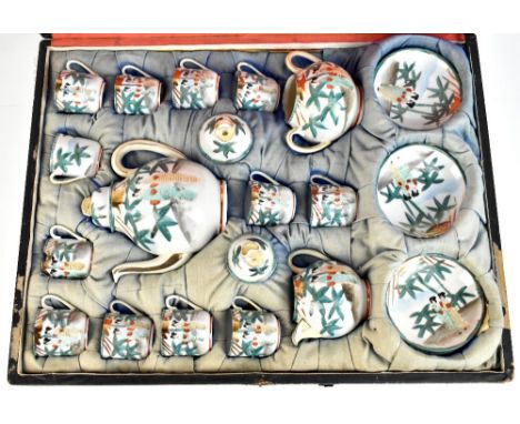 An early 20th century Japanese eggshell porcelain tea service decorated with figures and bamboo trees, in original wooden cra