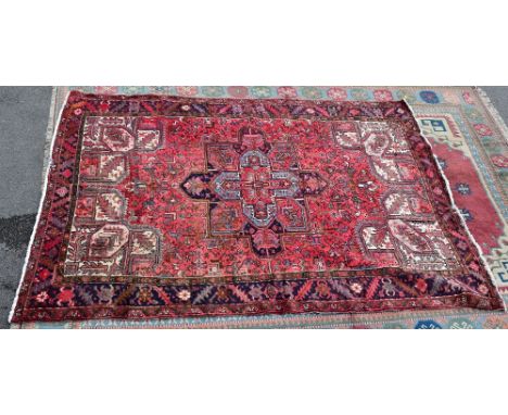 A large hand knotted Persian carpet, with elaborate geometric designs on a red ground within a multi-border, 230 x 320cm.