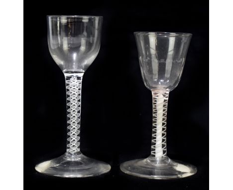 Two late 18th/early 19th century air twist wine glasses, the first with ogee bowl, raised on opaque stem, terminating on coni