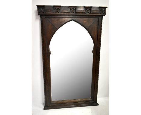 A good late 19th Century Gothic revival oak framed architectural wall mirror, with carved detail to the cornice and side pane