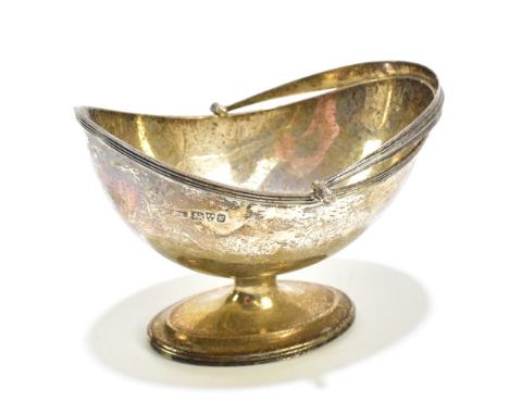 STOKES &amp; IRELAND LTD; a Edward VII hallmarked silver swing handled pedestal sugar basket with a cast rim, Chester 1907, a