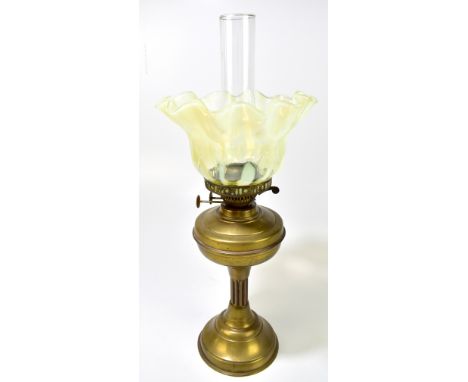 A small brass oil lamp with crimped vaseline glass shade and clear chimney on spreading circular base, height 57cm.Additional