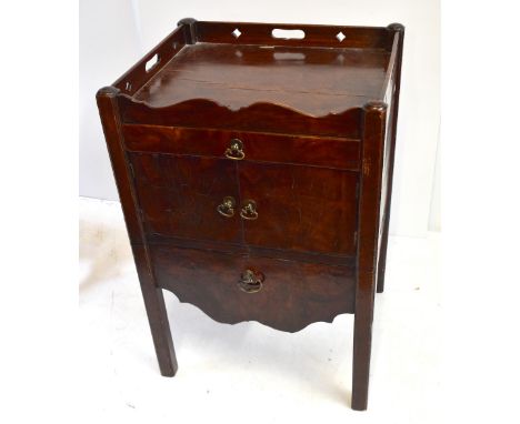 A George III mahogany night cupboard, with pierced gallery above drawer, pair of doors and commode drawer below, on square su