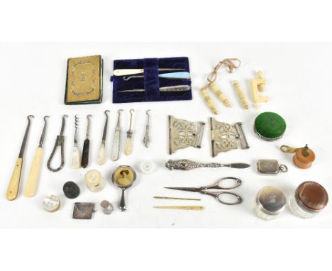 An interesting mixed collection of sewing accoutrements including a tape measure, enamel handle button hooks, sewing clamp, v