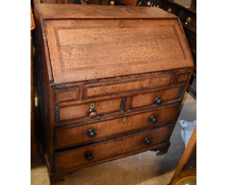 A Georgian oak bureau for restoration, the fall front above an arrangement of seven drawers on ogee bracket feet, 107.5 x 94 
