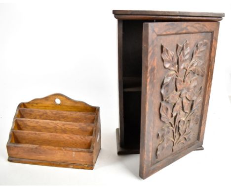 A small oak cupboard, the single door carved with floral decoration in relief enclosing single shelf, height 36.8cm, and a fo