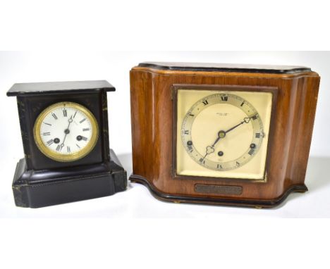 A late 19th century eight day black slate mantel clock, the circular enamelled dial set with Roman numerals and bearing rubbe