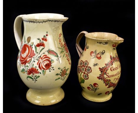 Two 18th century creamware jugs of baluster form (possibly Leeds), the first with relief detail to the rims, flanking floral 