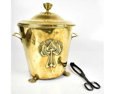 A brass twin handled lidded coal bucket with Art Nouveau relief floral decoration on three shaped feet with liner, height 42.