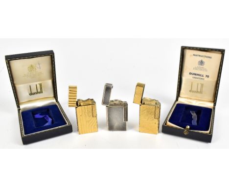 DUNHILL; a Dunhill 70 gold plated cigarette lighter and another both with textured detail to body, both in original branded b