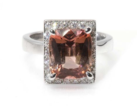 A platinum tourmaline and diamond rectangular cluster ring,with a cushion cut peach tourmaline, with a stated weight of 4.40c