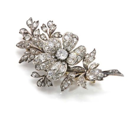 A Victorian diamond set spray brooch,with a central flower bloom, with an old cut diamond claw set at the centre. Graduated o