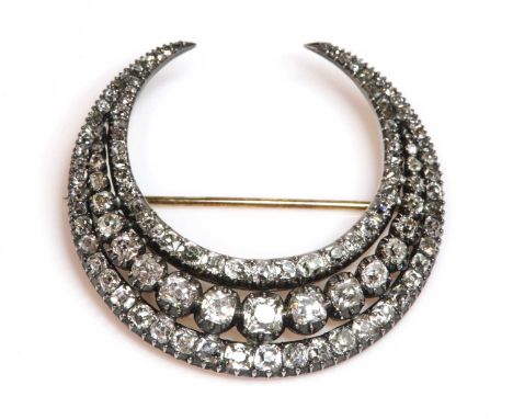 A Georgian diamond set closed crescent brooch,in a later case by Garrard &amp; Co. Ltd. The crescent with a central row of gr