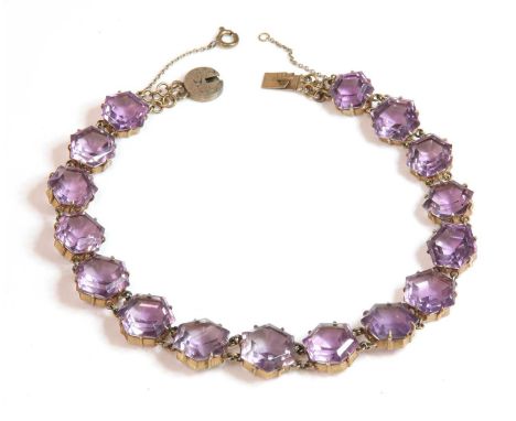 A Victorian gilt metal amethyst rivière necklace,with a series of graduated hexagonal step cut amethysts, all claw set in pla