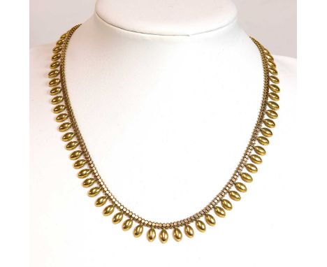 A Victorian gold fringe necklace,with a braided chain, decorated with applied discs, to an outer row of elliptical fringe lin