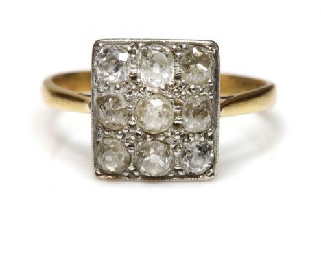 An Art Deco diamond set rectangular plaque ring,with a series of old European cut diamonds, pavé set to a white plaque. A sha