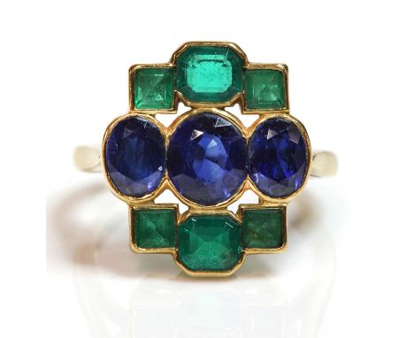 An Art Deco style sapphire and emerald plaque ring,mounted by Cartier. Three graduated oval mixed cut sapphires, rub set in a