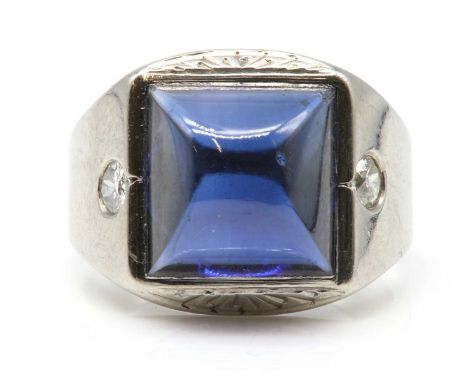 An American Art Deco synthetic sapphire and diamond ring, c.1930,with a square sugar loaf synthetic blue sapphire, rub set wi