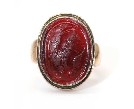 A glass intaglio ring depicting 'Lion Attacking a Bull',with an oval shallow brownish red glass cabochon, 19th century impres