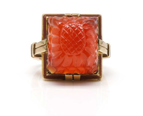 An American Art Deco cornelian and enamel ring, c.1935-1940,with a rectangular shaped carved sugar loaf cornelian, double cla